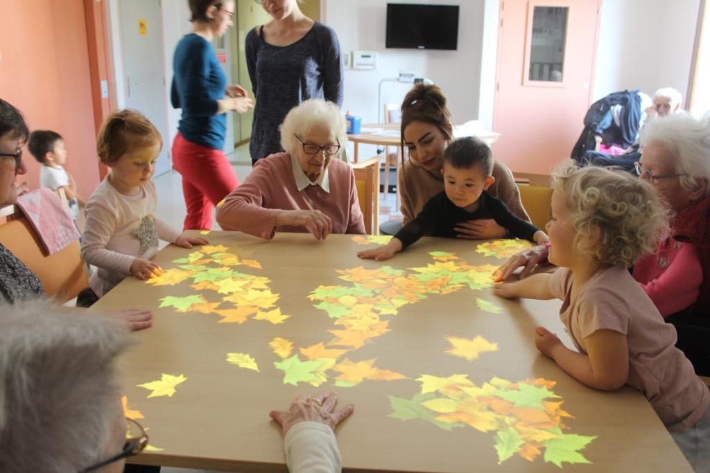 Des résidentes et leur famille en train de jouer au jeu "Feuilles"
